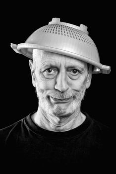 Dramatic black and white Portrait of a mad man with a plastic strainer on the head