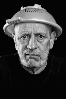 Dramatic black and white Portrait of a mad man with a plastic strainer on the head