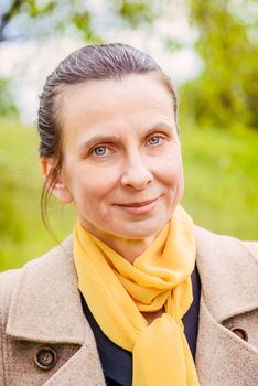 Portrait of a mature businesswoman with a coat and a yellow scarf