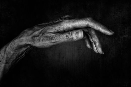 Black and White photo of senior woman hand on black background