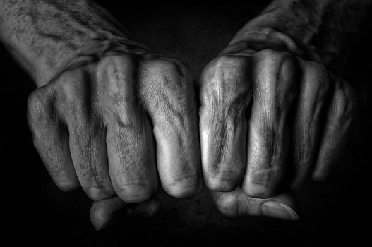 Black and White photo of senior woman fists on black background