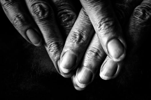 Black and White photo of senior woman fingers on black background
