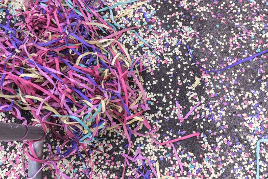 pile of confetti and paper streamer on the bitumen during a carnival