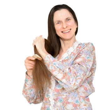 Adult woman combing long brown hair with a wooden comb, isolated on white background