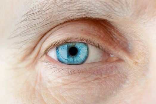 Macro of a hard contact lens on woman's blue eye