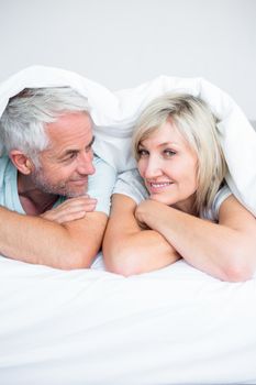 Closeup portrait of a mature couple lying in bed at home