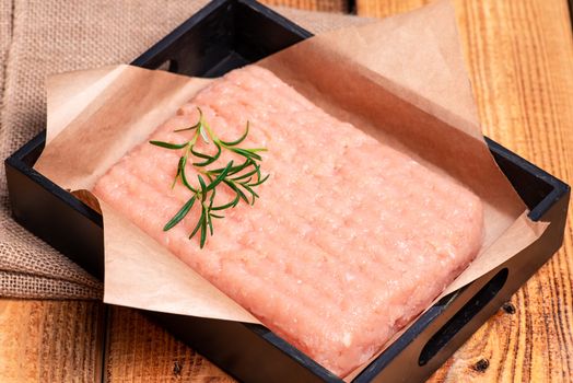 Raw Minced meat with herbs and spices,minced chicken close-up. Delicious diet meat. Top view.Raw minced chicken on a black plate on a wooden table. Top view.