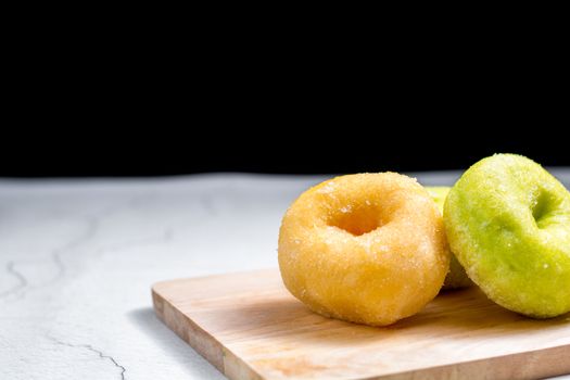 Vanilla and pandan doughnut on wooden chopping board. Breakfast concept.