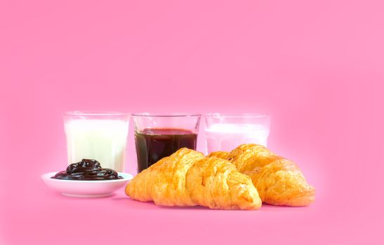 croissants served with glass of Fresh milk, coffee on pink background. Breakfast concept.