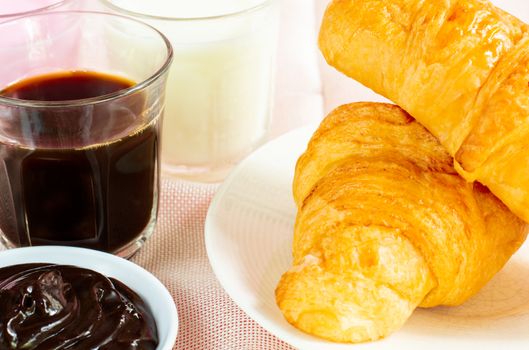 croissants served with glass of Fresh milk, coffee on pink background. Breakfast concept.