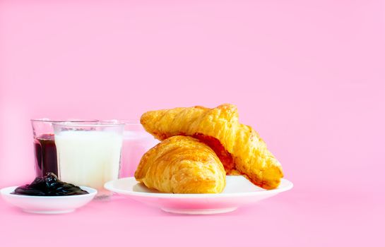 croissants served with glass of Fresh milk, coffee on pink background. Breakfast concept.