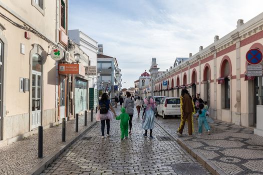 Loule, Faro, Portugal - February 25, 2020: street atmosphere in the city center during the carnival where people are walking on a winter day