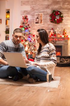 Romantic couple buying gifts from laptop using laptop for christmas.