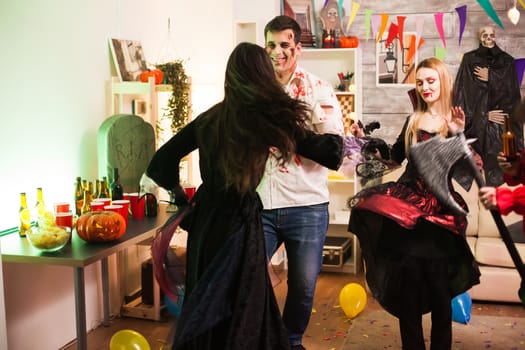 Back view of woman dressed up like a witch at halloween celebration.