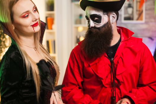 Man dressed up like a pirate trying to seduce vampire woman at halloween party.