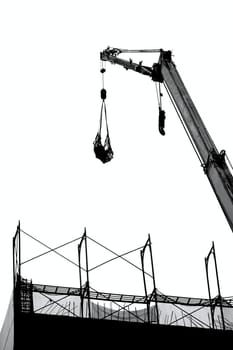 A crane lowers a load onto a construction site
