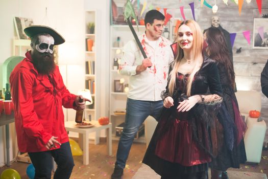 Shy blond woman dressed up like a vampire at halloween party.