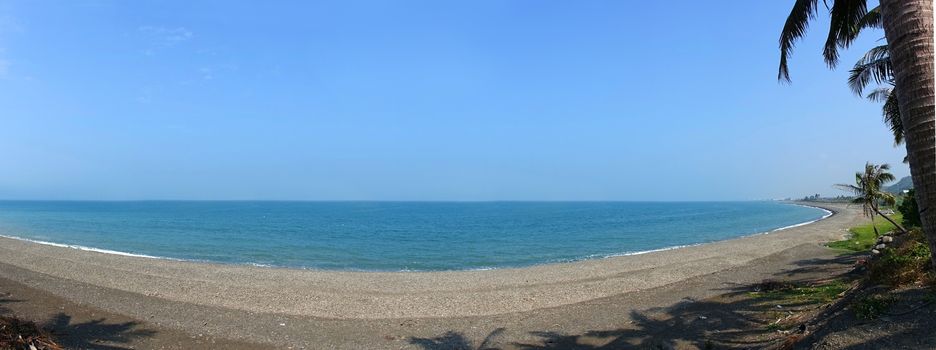Panoramic view of a long empty beach with palm trees in southern Taiwan
