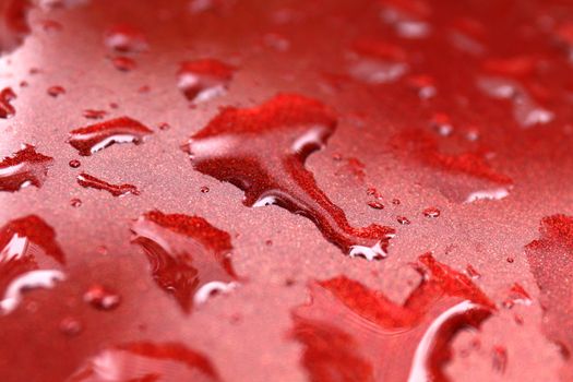 water droplets wet on red car's surface hood, water drop on red texture, water drop wet close-up (selective focus)