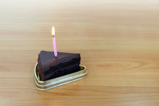 HBD cake Chocolate dark 1 piece crescent, Blowing Cake Candle brown, Happy Birthday one year anniversary on table wood