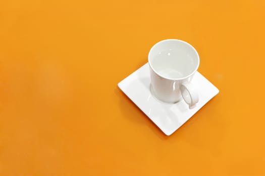 coffee cup white on top table orange, water mug white on background orange