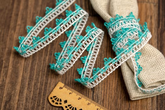 knitted emerald openwork linen ribbon tapes in rural style of rustics cotton eco natural on wood ground