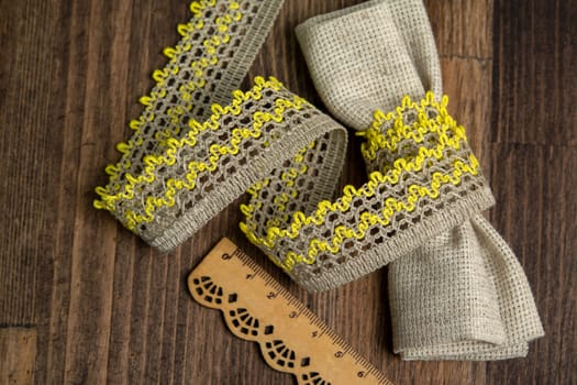 knitted yellow openwork linen ribbon tapes in rural style of rustics cotton eco natural on wood ground