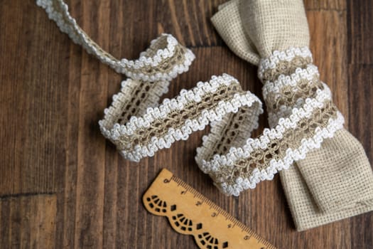 knitted white openwork linen ribbon tapes in rural style of rustics cotton eco natural on wood ground