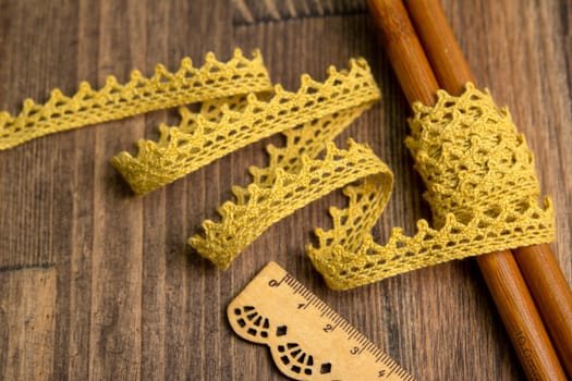 knitted yellow openwork linen ribbon tapes in rural style of rustics cotton eco natural on wood ground
