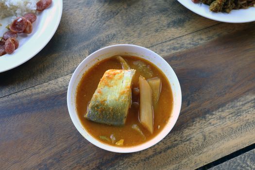 Yellow curry fish in bowl white thai southern style food, khaw khang-ti (Thai word), Large pieces of fish soup in a cup is Thai Asia food Popular Diets