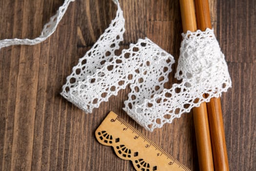 knitted white openwork linen ribbon tapes in rural style of rustics cotton eco natural on wood ground