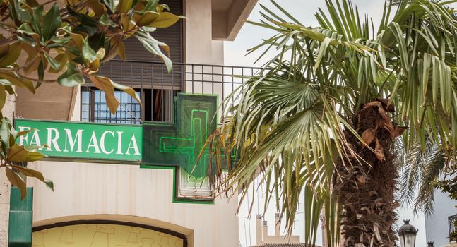 Valencia, Spain - June 16, 2017: Pharmacy sign in a small square in the historic city center on a summer day