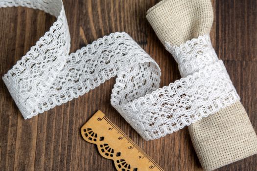 knitted white openwork linen ribbon tapes in rural style of rustics cotton eco natural on wood ground