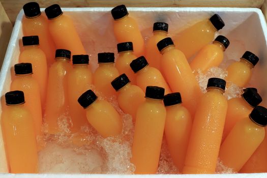 Orange Juice fresh in bottle ice cooler at market street food (Selective Focus)