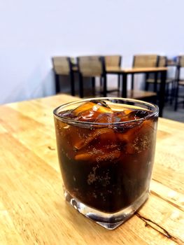 Cola in glass ice, Pouring cola from glass bottles drinks to a glass with ice cubes, cola in glass ice beverage Drinks on the restaurant table