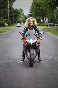 Young woman, on a sport motocyle, ready to roll in the street