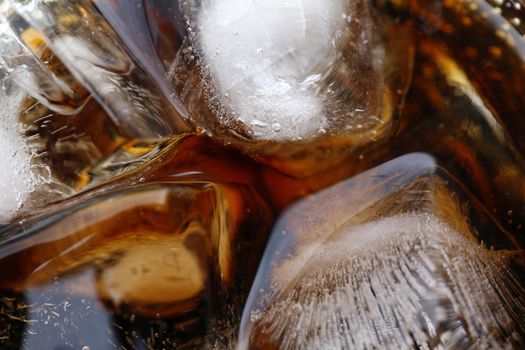 close-up beverage cola and cubes ice refreshing cool in glass, black cola soda in glass with ice cubes for refreshments feel for background
