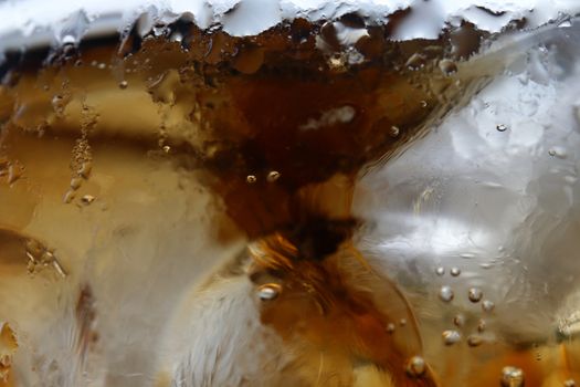close-up beverage cola and cubes ice refreshing cool in glass, black cola soda in glass with ice cubes for refreshments feel for background