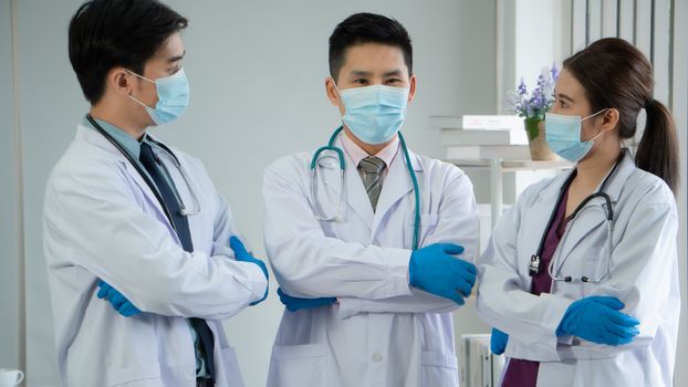 The virus is spreading strongly. Medical team Asian people wear protective masks and meeting together at the hospital.