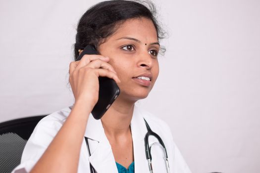 Close up shot of Female doctor talking on mobile phone in her office - concept of telehealth, telehealth service during coronavirus or covid-19 outbreak.