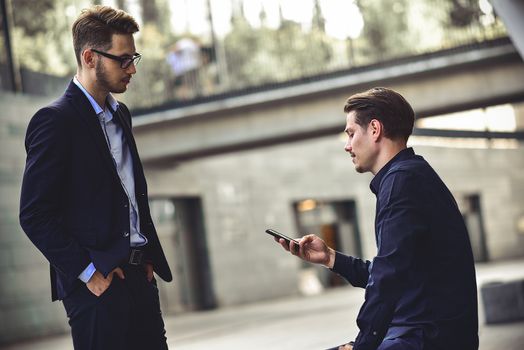 Upset young caucasian man reading a message on his mobile phone.