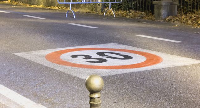 speed limit sign on a tarmac road by night in Italy