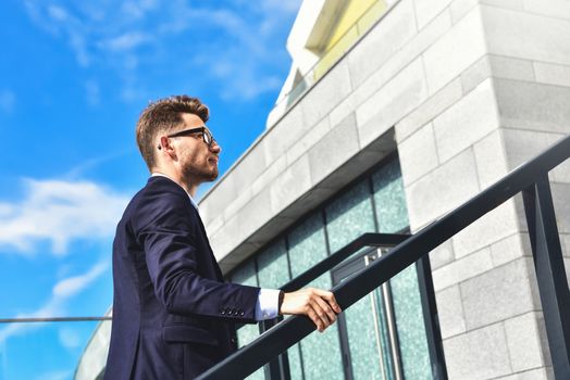 Handsome successful businessman in elegant suit outdoors walking on street in the city.