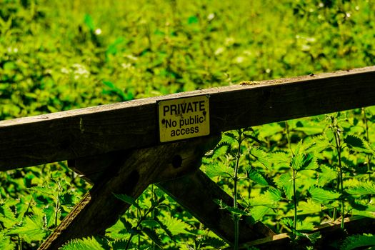 Private farm land fenced off by a large gate, close up of the private sign showing no access to the rural pathway