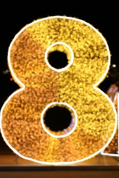 Alphabet Number Eight Gold, Blurred Bokeh letter eight (8) gold font type colorful lighting Glittering shine yellow on night black background