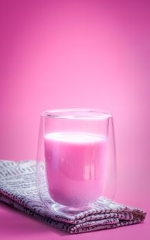 Summer drink concept. Strawberry pink milk with froth milk in clear glass on pink background. 