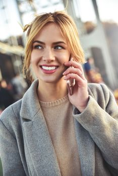 Portrait of beautiful young woman in urban background talking on phone