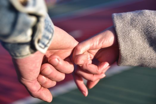 Hand in hand. Man and woman holding by hands in the city