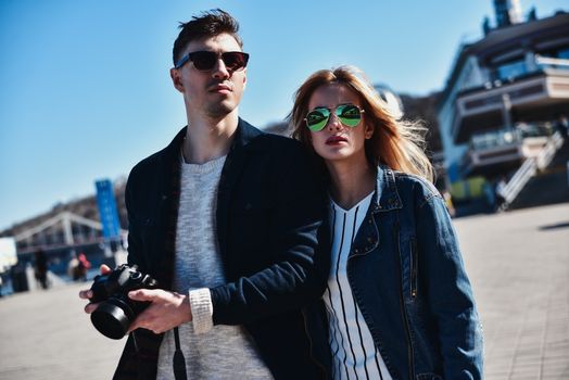 Romantic couple walk at the street with photo camera