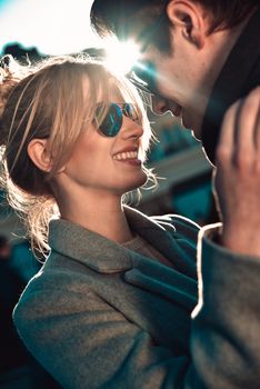 Happy playful couple in sunglasses in love dating joking and laughing in the street